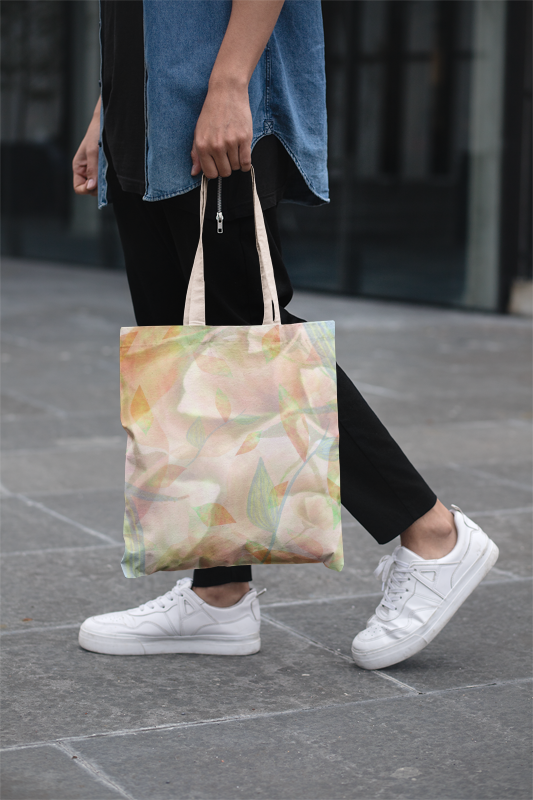 Person holding a floral tote bag on a pavement